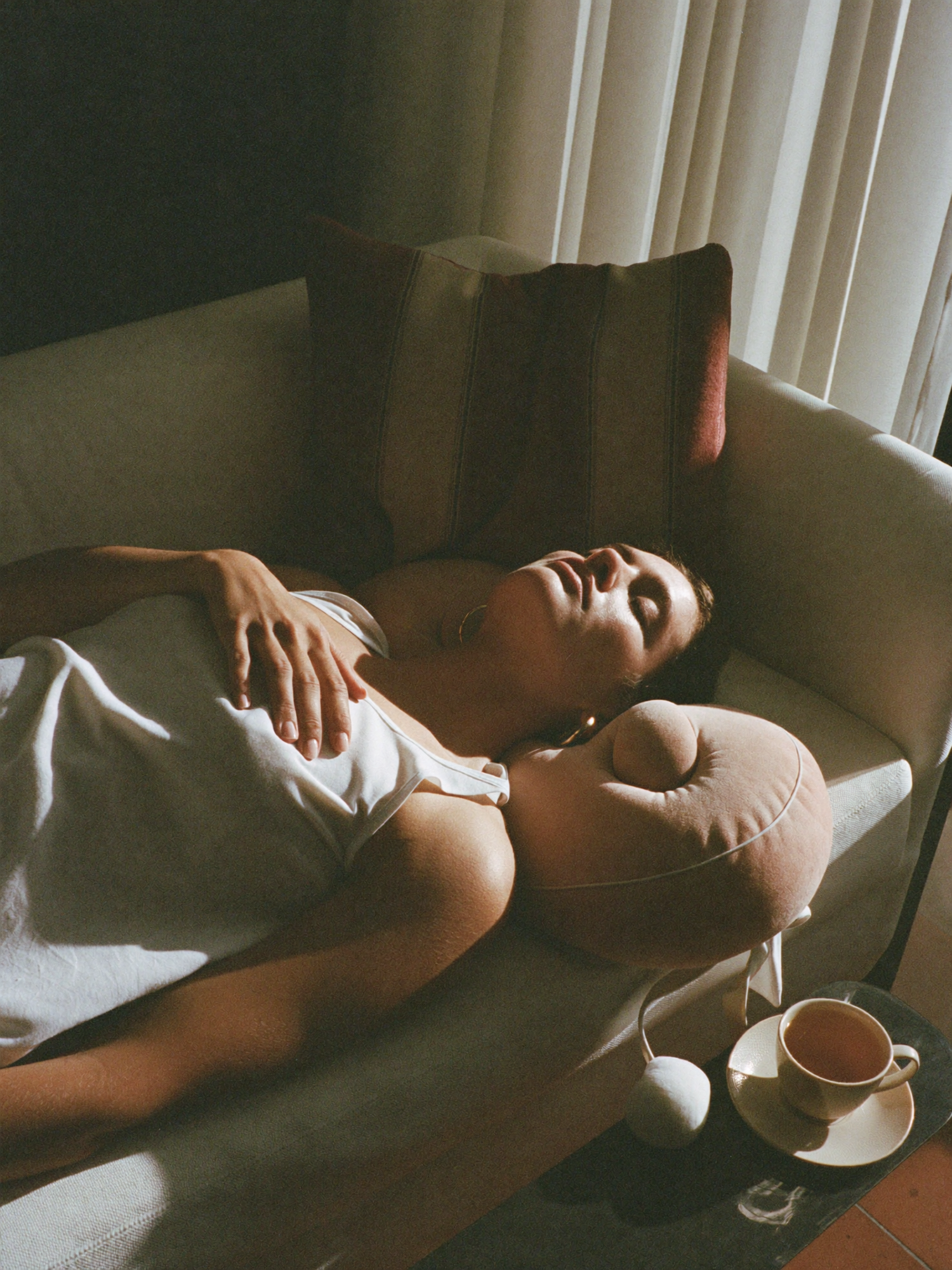 A woman leaning back into a massage cushion on the sofa in golden hour light